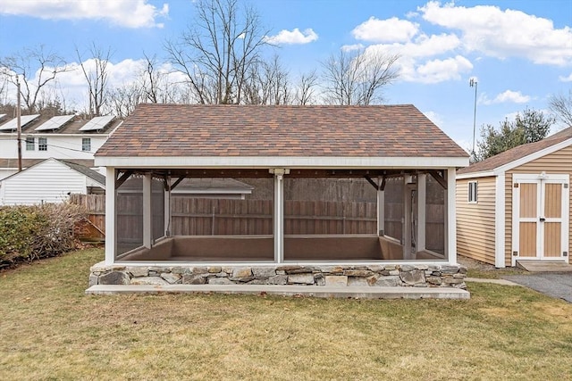 exterior space with a sunroom and a shed