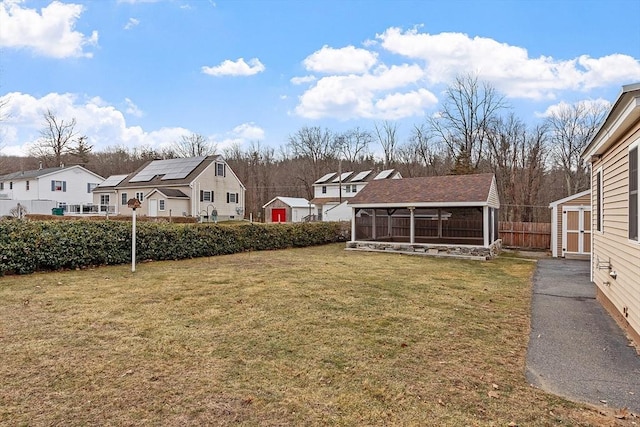 view of yard featuring a sunroom and an outbuilding