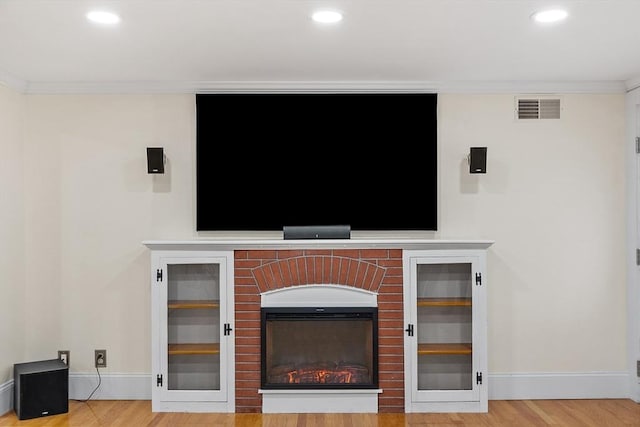 interior details with hardwood / wood-style flooring, crown molding, and a fireplace