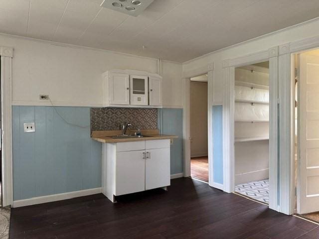 40 Allen St, Greenfield, MA 01301 - kitchen featuring a sink, dark wood-type flooring, white cabinets, decorative backsplash, and crown molding