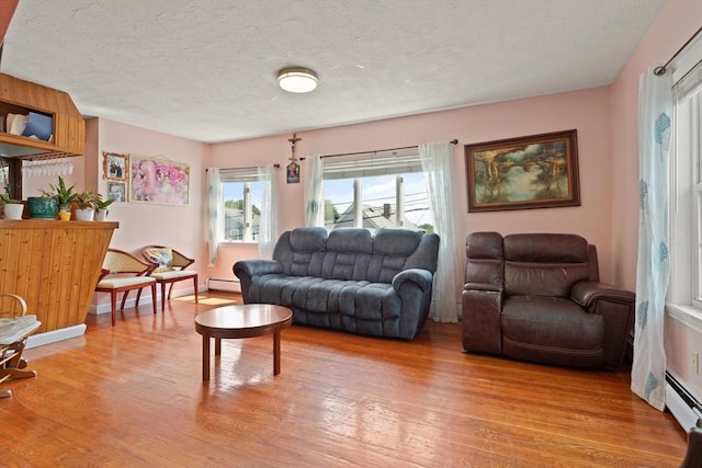 66 Adams St, Revere, MA 02151 - living area featuring light wood-style floors, a baseboard heating unit, and a textured ceiling