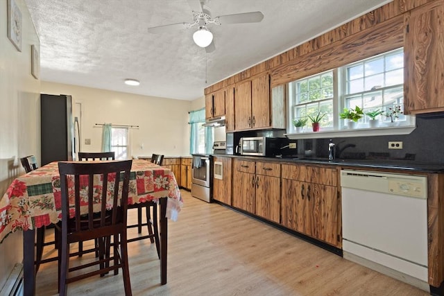 66 Adams St, Revere, MA 02151 - kitchen with appliances with stainless steel finishes, brown cabinets, healthy amount of natural light, and a textured ceiling