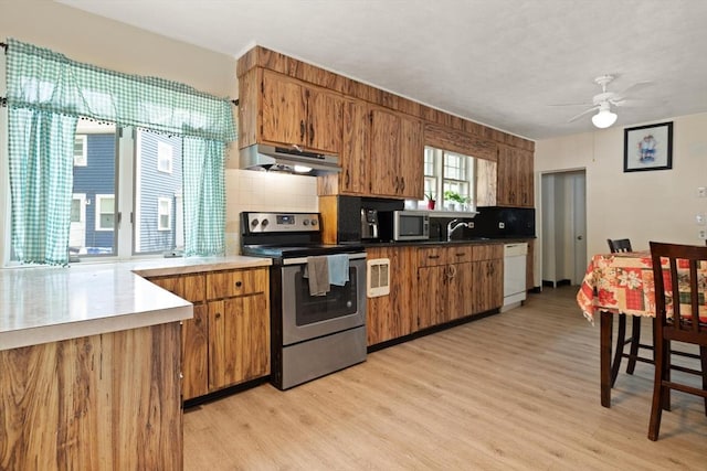 66 Adams St, Revere, MA 02151 - kitchen featuring appliances with stainless steel finishes, under cabinet range hood, light wood-style floors, and brown cabinetry