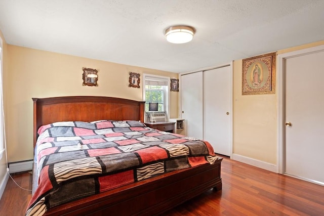 66 Adams St, Revere, MA 02151 - bedroom featuring wood finished floors, a closet, a baseboard heating unit, and a textured ceiling