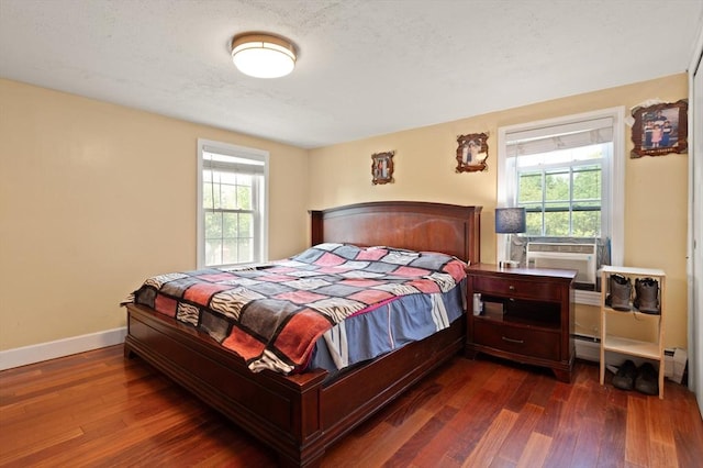 66 Adams St, Revere, MA 02151 - bedroom with dark wood-style flooring, multiple windows, baseboard heating, and a textured ceiling