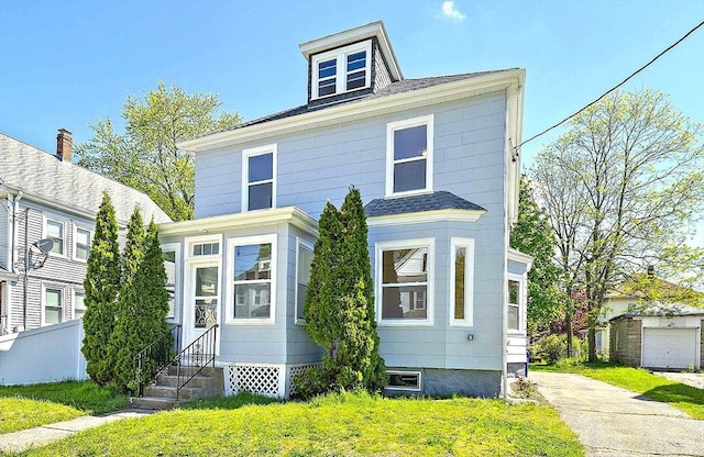 american foursquare style home with entry steps, a front lawn, and roof with shingles