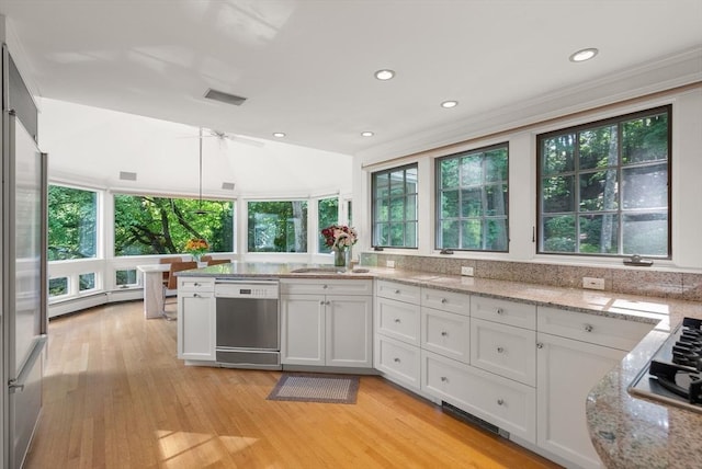 kitchen with a baseboard heating unit, appliances with stainless steel finishes, light stone counters, and white cabinets