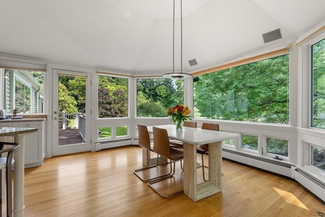 sunroom with a baseboard heating unit and vaulted ceiling