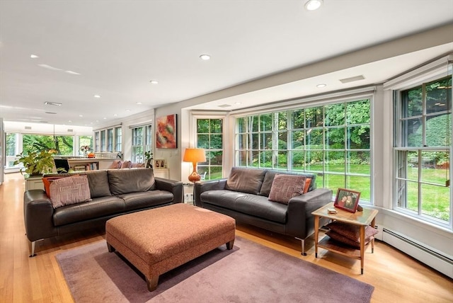 living area featuring light wood-style floors, baseboard heating, and recessed lighting