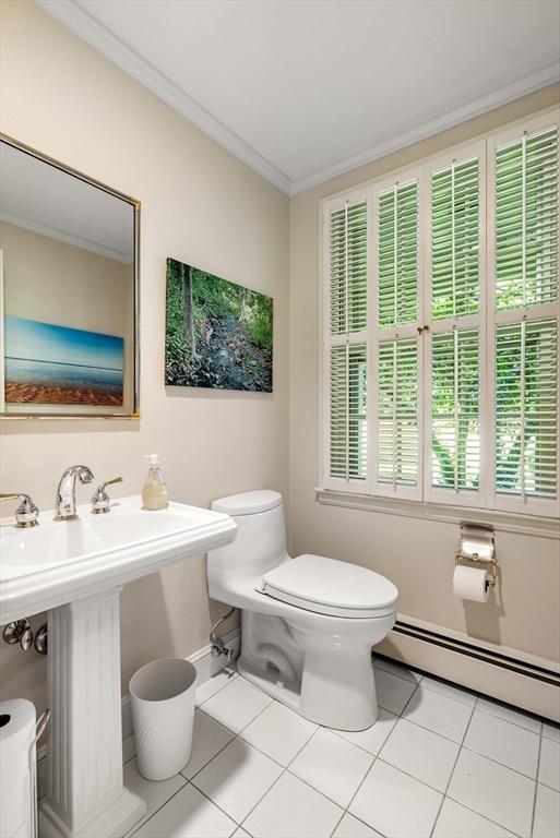 bathroom with a baseboard radiator, tile patterned flooring, crown molding, and toilet