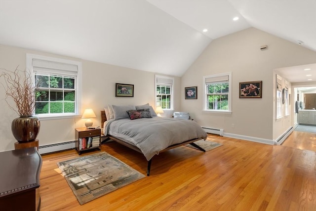 bedroom with a baseboard heating unit and light wood finished floors