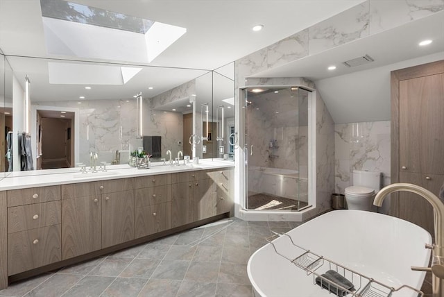 bathroom featuring double vanity, a skylight, a marble finish shower, a soaking tub, and tile walls