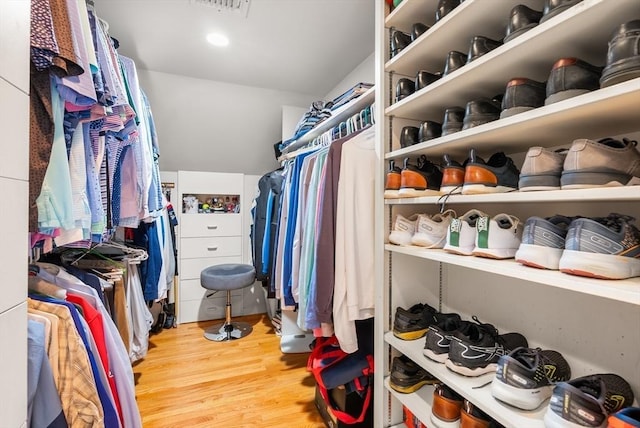 walk in closet with light wood-style floors