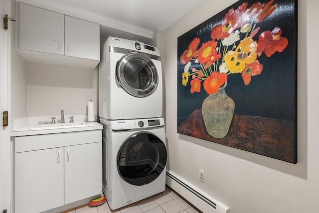 laundry room featuring cabinet space, baseboard heating, stacked washing maching and dryer, a sink, and light tile patterned flooring