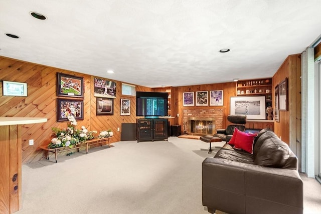 living area with wooden walls, recessed lighting, a fireplace, and light colored carpet