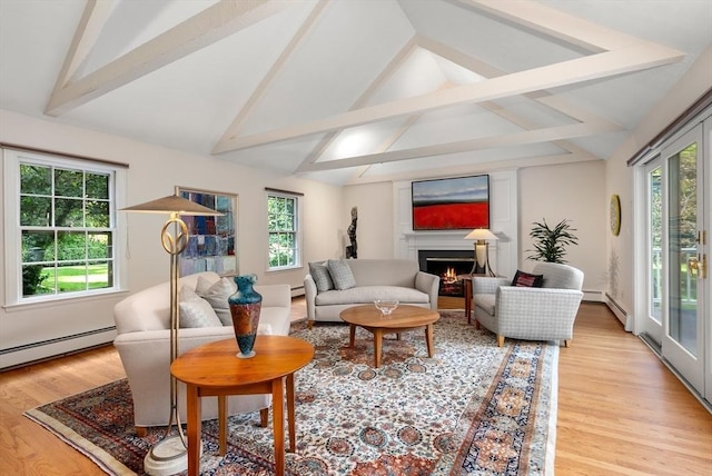 sitting room featuring a baseboard radiator, light wood-style flooring, and a lit fireplace