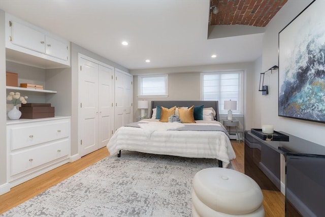 bedroom with recessed lighting, a baseboard radiator, and light wood-style floors