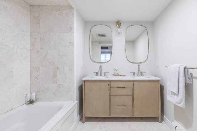 full bathroom featuring visible vents, a sink, double vanity, and a tub to relax in