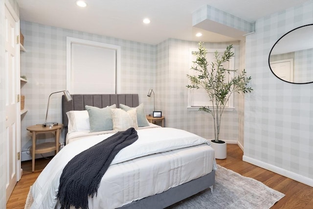 bedroom featuring wallpapered walls, baseboards, and light wood-style floors