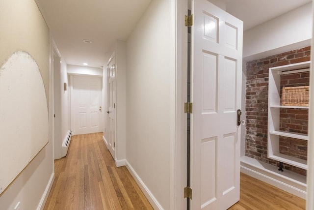 hall with light wood-style floors, baseboards, and a baseboard radiator