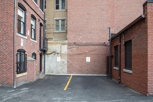 view of side of property featuring uncovered parking and brick siding