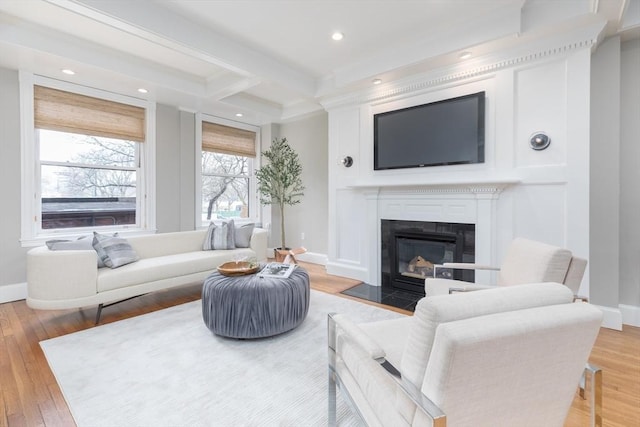 living room with wood finished floors, beamed ceiling, baseboards, recessed lighting, and a fireplace with flush hearth