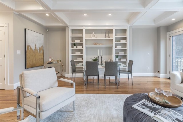 living area with baseboards, beamed ceiling, coffered ceiling, and wood finished floors