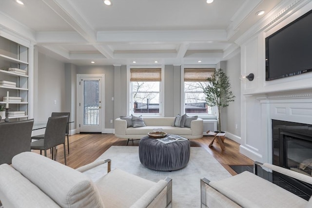 living room with crown molding, baseboards, coffered ceiling, and wood finished floors