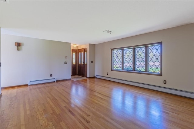 unfurnished living room with a baseboard radiator, wood finished floors, a baseboard heating unit, and baseboards