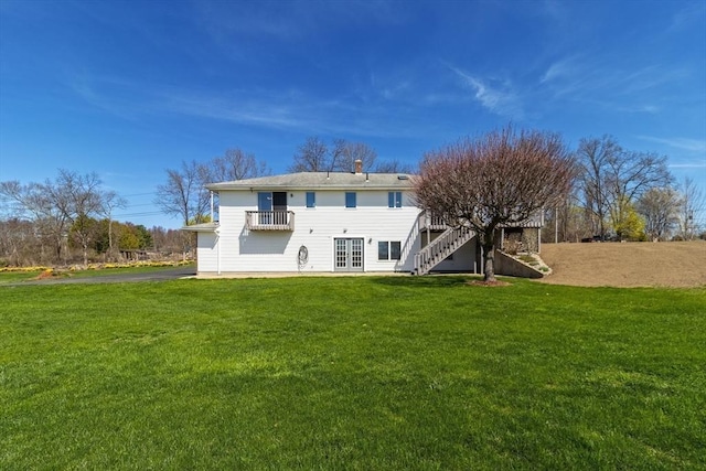 back of property featuring french doors, aphalt driveway, a yard, and stairs