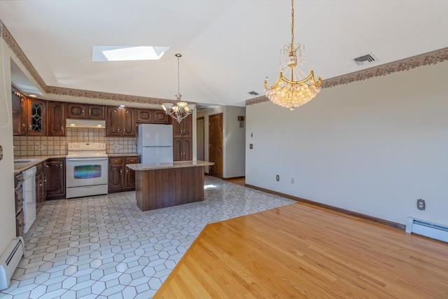 kitchen with a skylight, white appliances, a chandelier, a baseboard heating unit, and under cabinet range hood
