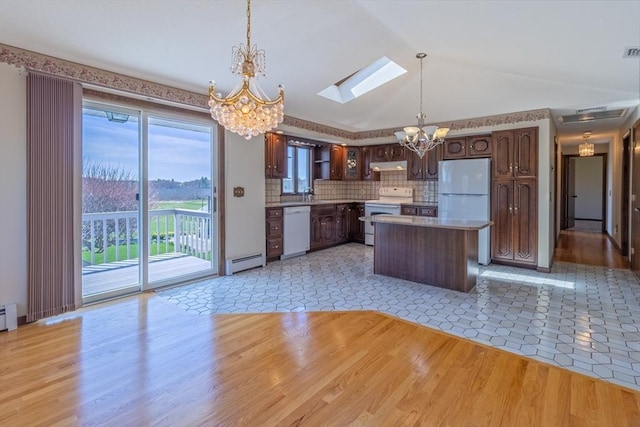 kitchen with light wood-style flooring, baseboard heating, a center island, an inviting chandelier, and white appliances