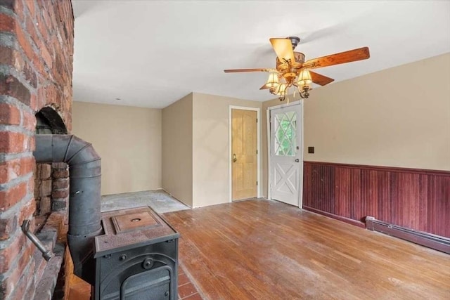 110 Northbridge Rd, Mendon, MA 01756 - entryway with wood finished floors, a wood stove, a baseboard radiator, a ceiling fan, and wainscoting