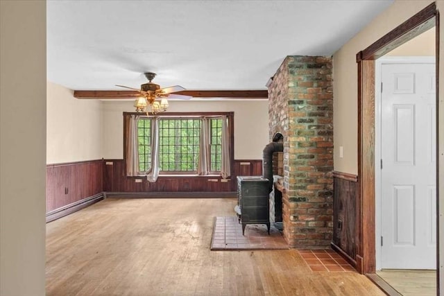 110 Northbridge Rd, Mendon, MA 01756 - unfurnished living room with wainscoting, a wood stove, a ceiling fan, wood walls, and wood finished floors