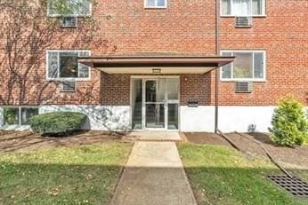 22 Bryon Rd Unit 3, Boston, MA 02467 - view of exterior entry featuring brick siding and a lawn