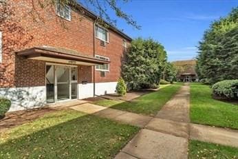 22 Bryon Rd Unit 3, Boston, MA 02467 - view of side of home featuring brick siding and a yard