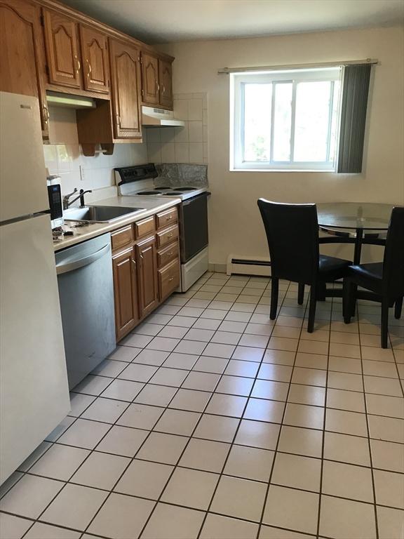 22 Bryon Rd Unit 3, Boston, MA 02467 - kitchen with white appliances, a sink, under cabinet range hood, baseboard heating, and light countertops