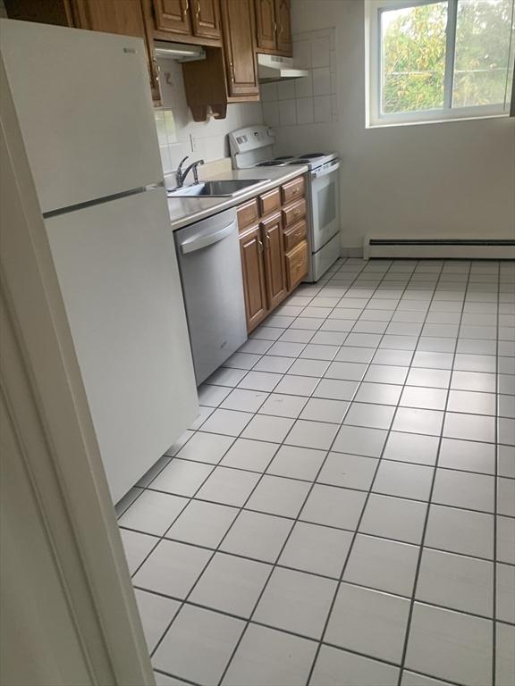 22 Bryon Rd Unit 3, Boston, MA 02467 - kitchen with white appliances, a baseboard radiator, under cabinet range hood, a sink, and light countertops