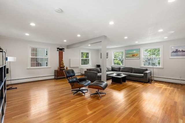 living area with light wood-type flooring, a baseboard heating unit, and recessed lighting