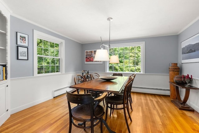 dining room with ornamental molding, light wood finished floors, and a baseboard radiator