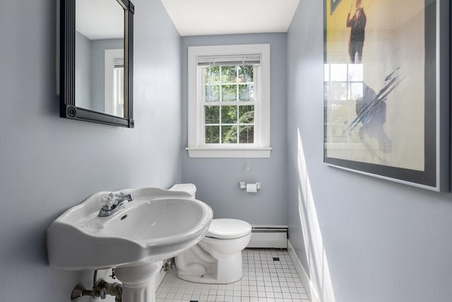 half bath with tile patterned floors, baseboard heating, toilet, and baseboards