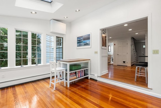 dining room with recessed lighting, baseboard heating, a skylight, and hardwood / wood-style flooring