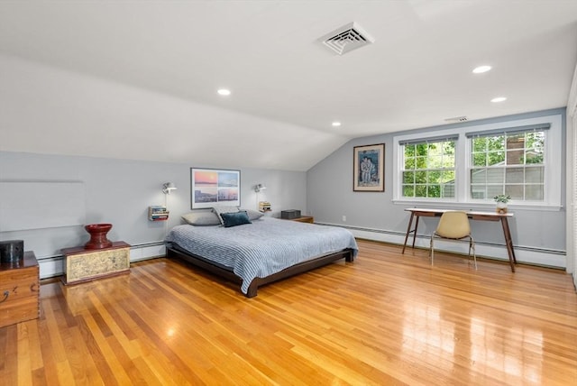 bedroom with a baseboard heating unit, lofted ceiling, light wood-style flooring, and visible vents