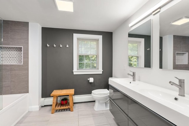 bathroom featuring double vanity, toilet, baseboards, and a sink