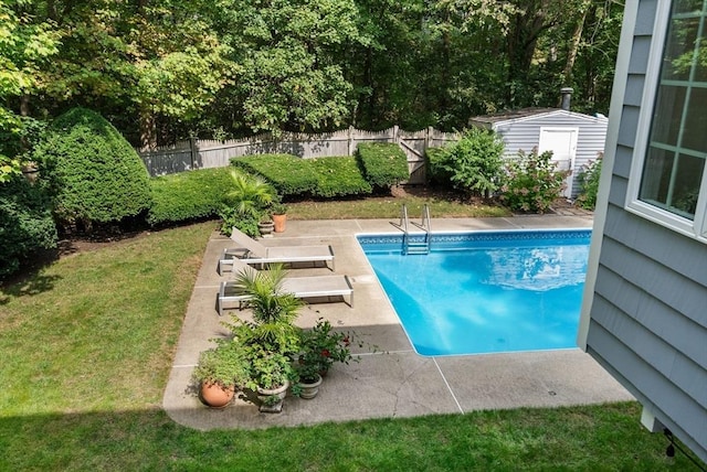 view of pool featuring an outbuilding, fence, a fenced in pool, a yard, and a patio area