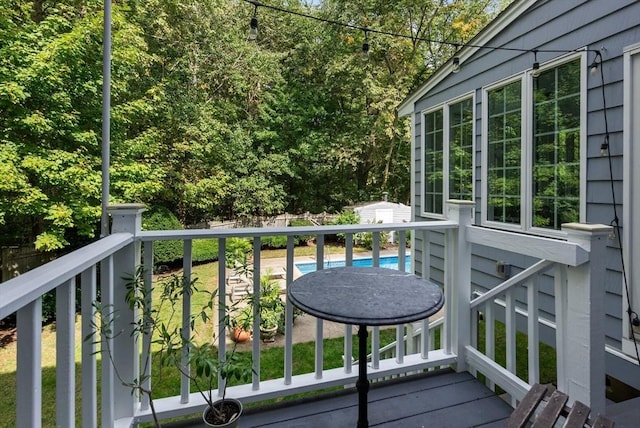 wooden deck featuring a storage shed, an outdoor structure, and fence