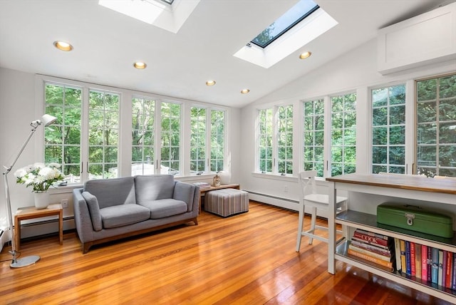 sunroom with a wealth of natural light, a baseboard heating unit, and lofted ceiling with skylight