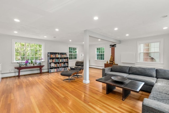 living room featuring a wealth of natural light, light wood-style flooring, and baseboard heating