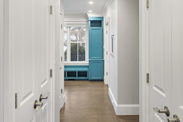 corridor featuring recessed lighting, wood finished floors, baseboards, and ornamental molding