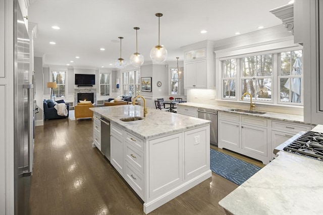 kitchen with stainless steel dishwasher, an island with sink, and a sink